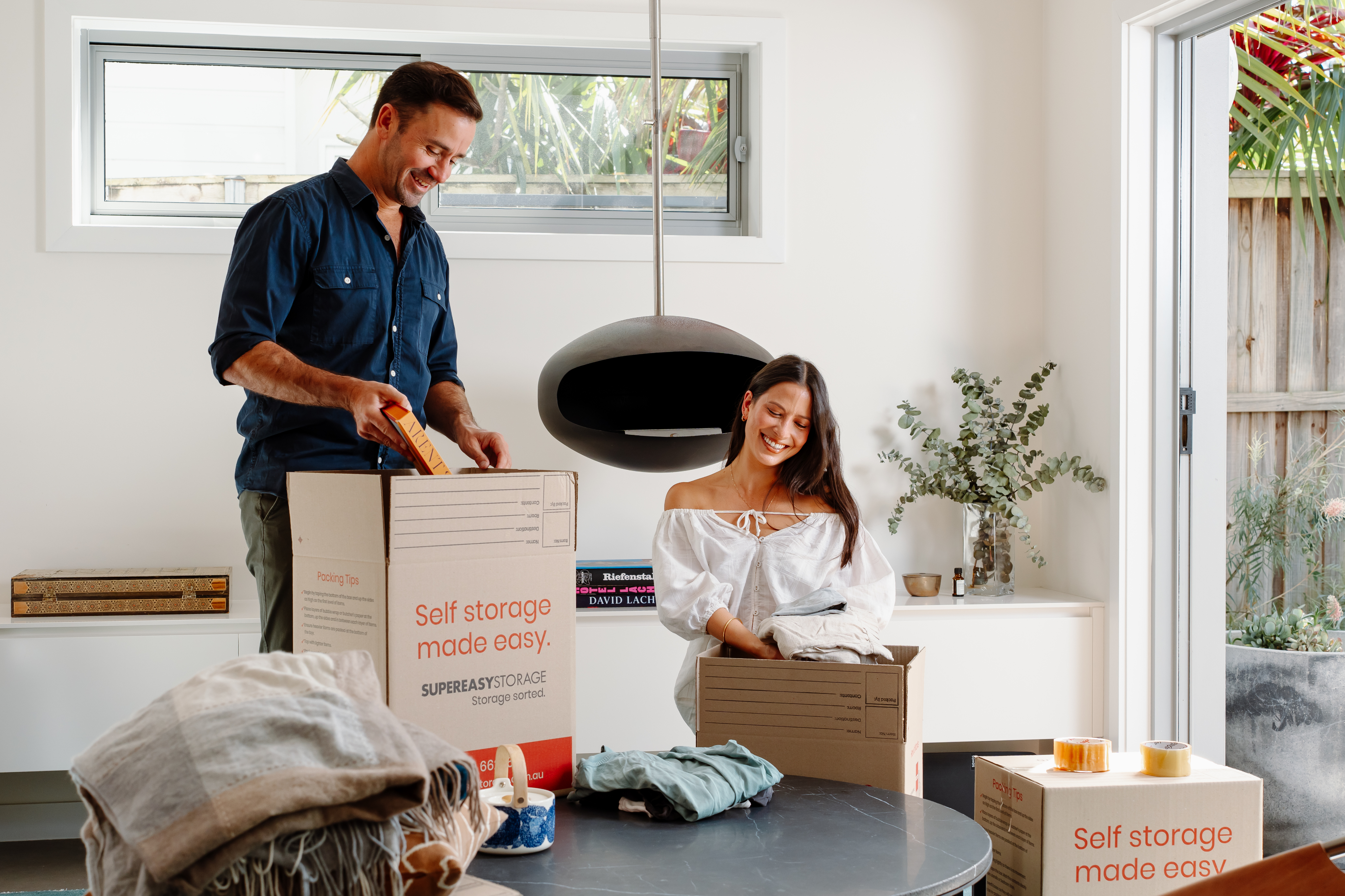 Couple packing boxes for storage at home